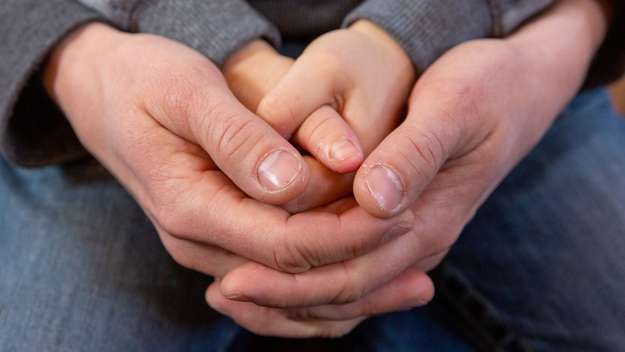 Betende Hände eines Kindes und eines Erwachsenen, ineinandergelegt