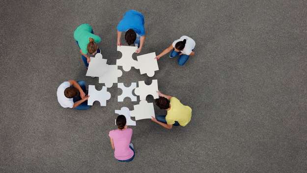 Symbolbild: Menschen legen große Puzzleteile zusammen
