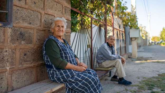 Aelteres Paar sitzt an einer Straße in Echmiadzin, Armenien