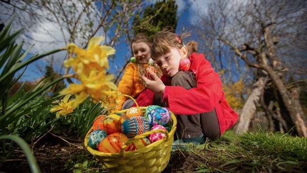 Kinder im Garten mit einem Körbchen voller Ostereier