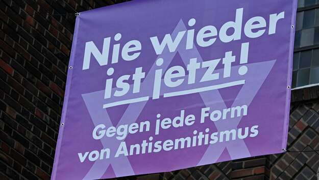 Banner mit der Aufschrift 'Nie wieder ist jetzt! Gegen jede Form von Antisemitismus' an der katholischen St. Bonifatiuskirche in Frankfurt