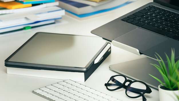 Tisch mit Laptop, Tablet und Büchern