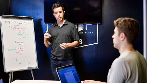 Zwei Männer mit Laptop und Flipchart