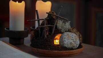 Osterszene mit Kerzen, Kreuzen und Steinen