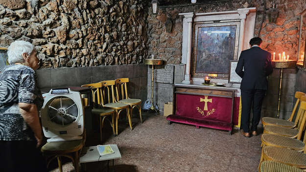 In der Syrisch-Orthodoxen Sankt-Georgskapelle, Damaskus: Eine alte Frau schaut zu einem Mann, der betet In der Syrisch-Orthodoxen Sankt-Georgskapelle, Damaskus: Eine alte Frau schaut zu einem Mann, der betet