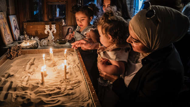 Eine Kirche in Homs, Syrien: Eine Frau (Christin) zeigt ihrer Freundin (Muslimin) die Kirche, gemeinsam mit ihren Kindern zünden sie Kerzen an. Eine Kirche in Homs, Syrien: Eine Frau (Christin) zeigt ihrer Freundin (Muslimin) die Kirche, gemeinsam mit ihren Kindern zünden sie Kerzen an.