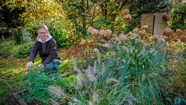 Gärtnerin Jasmin Laudenbach pflegt ein Grab in Hannover