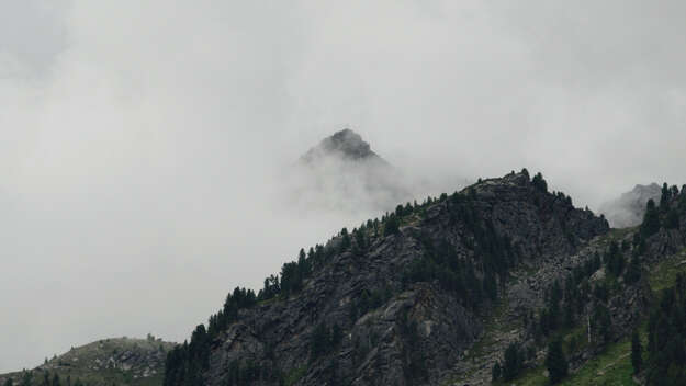 Ein Berggipfel ragt aus den Wolken