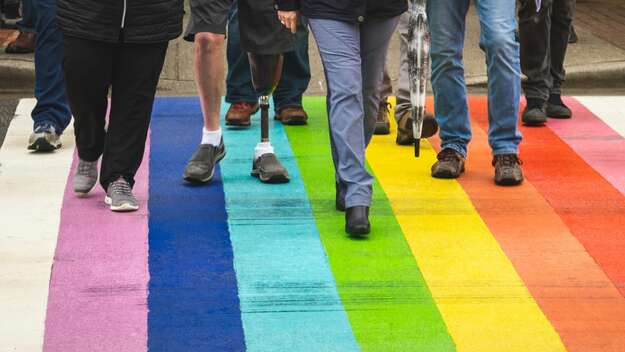 Gruppe von Menschen gehen über eine bunte Straße
