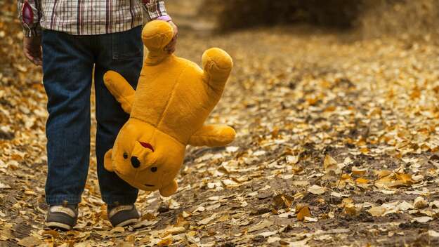 Eine Kinderhand, die einen Teddy hält