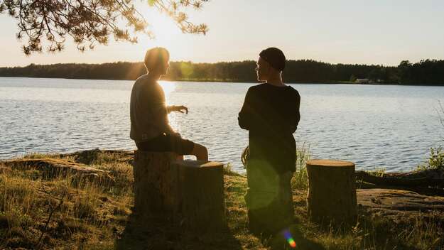 Zwei Männer unterhalten sich im Gegenlicht der Abendsonne