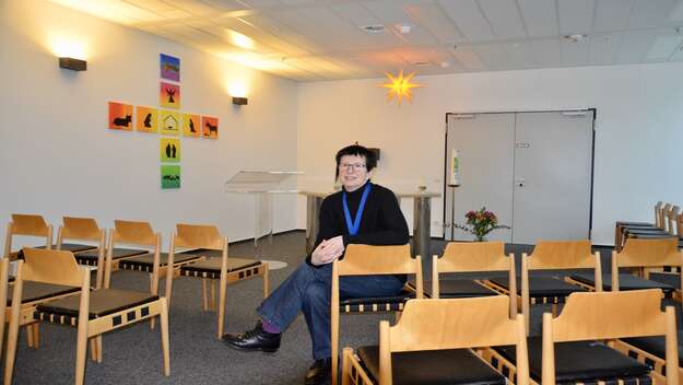 Flughafenpfarrerin Bettina kluenemann sitzt im Kirchenraum der evangelischen Kirche am Flughafen