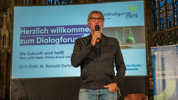 Ein Mann mit Mikrofon in der Hand beim Dialogforum in der St. Reinoldi Kirche in Dortmund