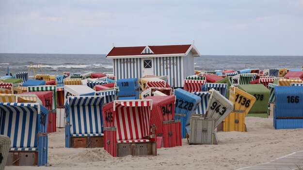 Zu sehen sind die bunten Strandkörbe am Strand von Langeoog
