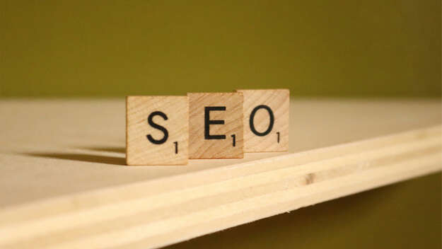 Drei Holzklötze mit Buchstaben, die das Wort SEO ergeben