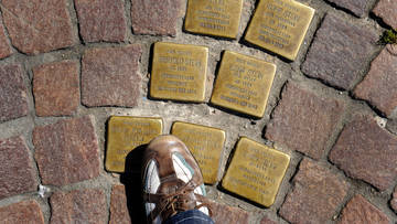 Ein Fuß auf goldenen 'Stolpersteinen' in Seligenstadt
