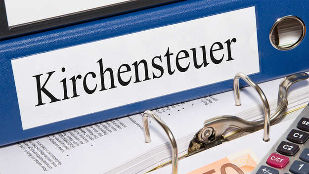 Kirchensteuer Ordner mit Geld und Taschenrechner im Büro