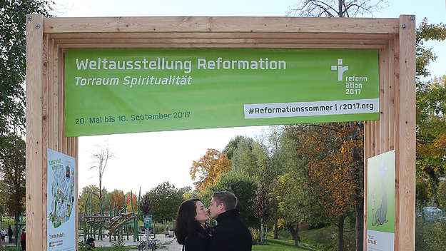 Ein Paar küsst sich unter einem der Torräume des Vereins Reformation 2017 in Wittenberg.