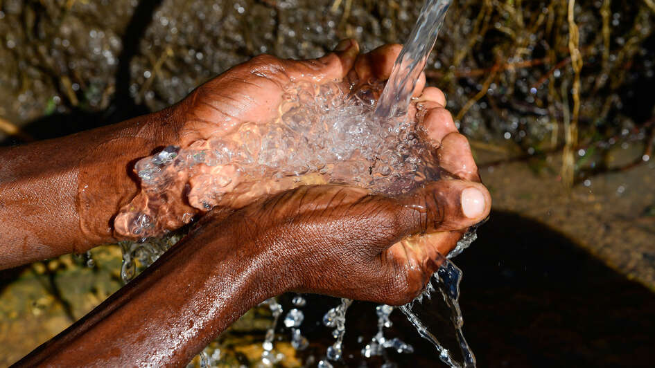 Hände unter einem Wasserstrahl Hände unter einem Wasserstrahl