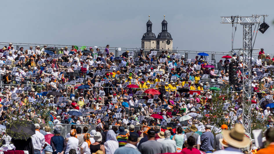 Teilnehmer am großen Festgottesdienst vor der Silhouette der Schlosskirche Wittenberg