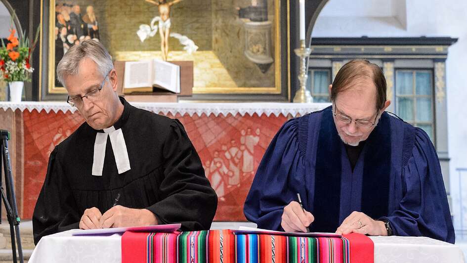 Generalsekretär der Weltgemeinschaft Reformierter Kirchen, Chris Ferguson (re.), und der Generalsekretär des Lutherischen Weltbundes, Martin Junge, unterzeichnen Generalsekretär der Weltgemeinschaft Reformierter Kirchen, Chris Ferguson (re.), und der Generalsekretär des Lutherischen Weltbundes, Martin Junge, unterzeichnen
