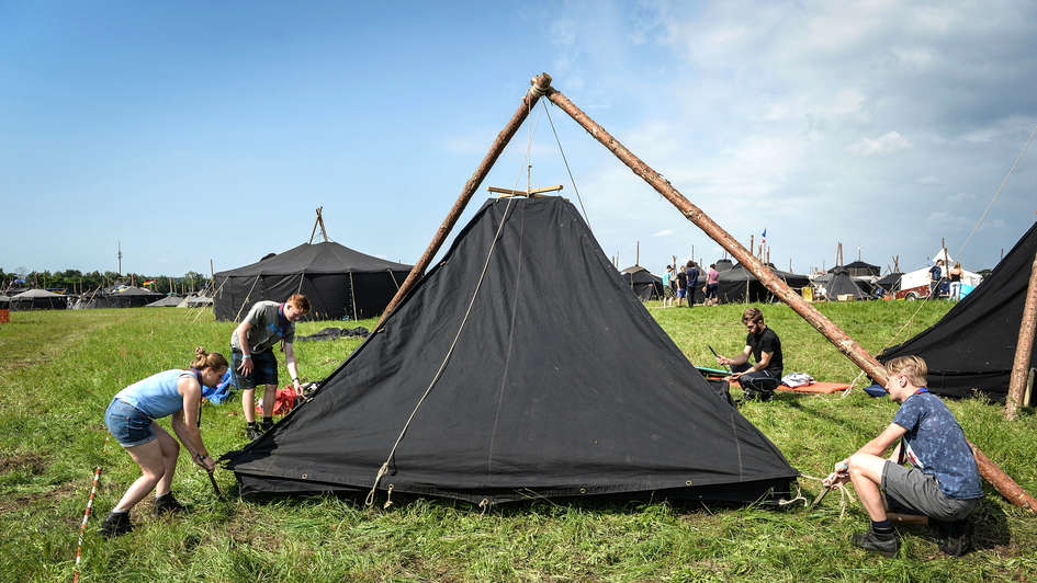 Vier Jugendliche bauen Zelt auf