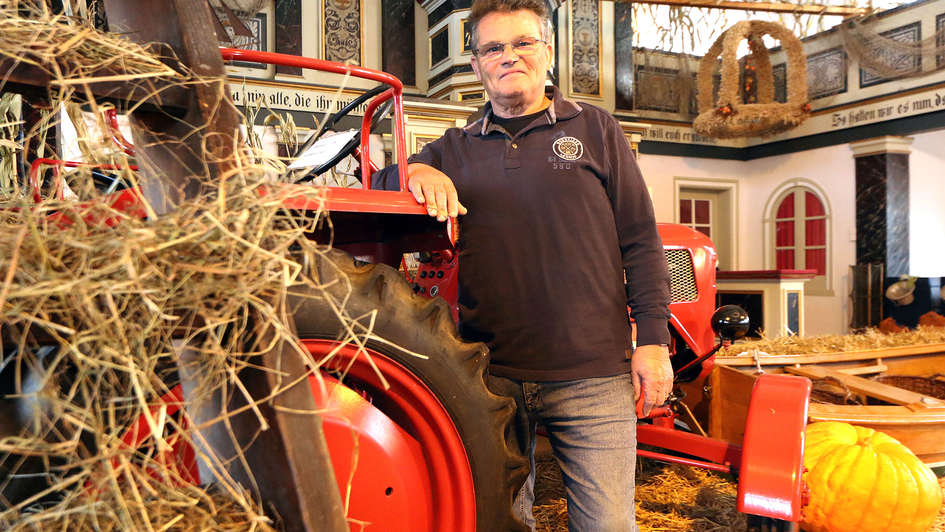 Küster Günther Burwieck vor dem Traktor in der Kirche