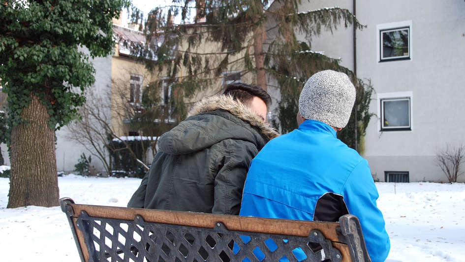 Zwei Männer sitzen auf einer Bank