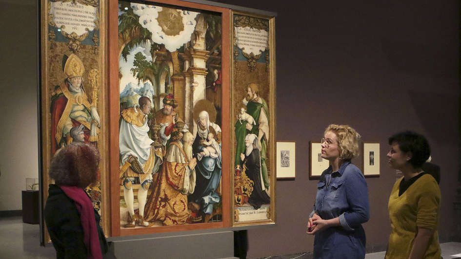 Ausstellungsbesucherinnen betrachten ein Altarbild des „Meisters von Meßkirch“