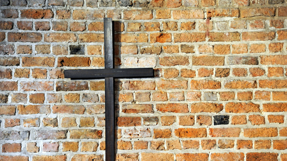 Kreuz an einer Backsteinwand