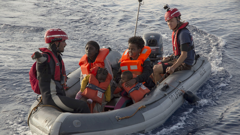 Mitarbeiter der „Mission Lifeline“ bringen Flüchtlinge auf einem Schlauchboot zu einem Rettungsschiff