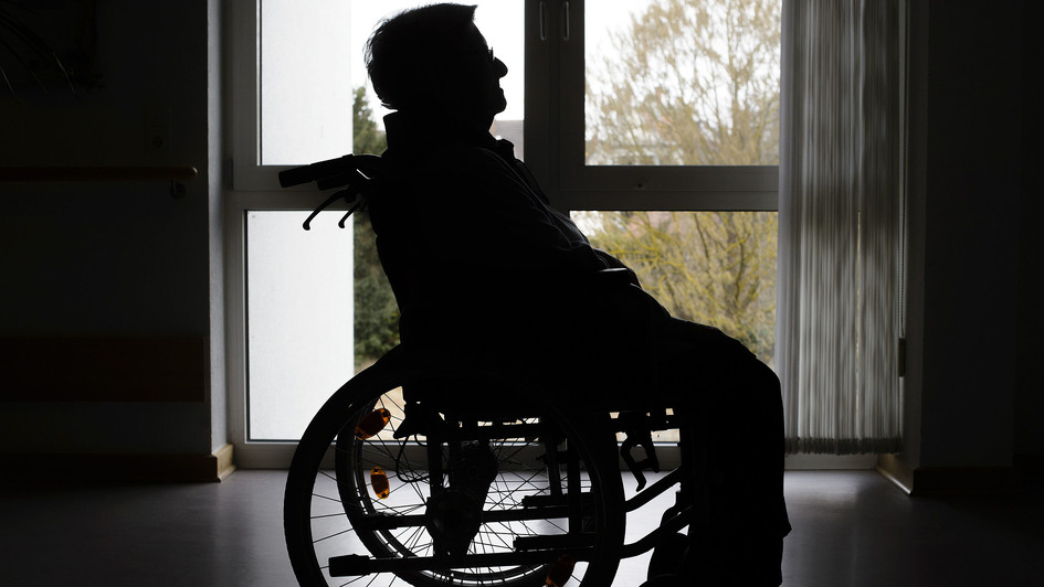 Alter Mann im Rollstuhl im Gegenlicht, Symbolbild