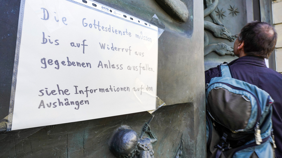 Verschlossene Kirchentür mit Schild, dass Gottesdienst wegen Coronakrise ausfällt Verschlossene Kirchentür mit Schild, dass Gottesdienst wegen Coronakrise ausfällt