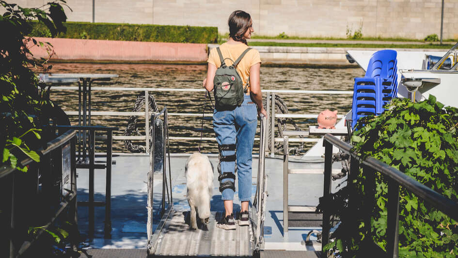 Eine junge Frau mit einer Schiene am Bein benutzt einen Aufzug am Bahnhof. Eine junge Frau mit einer Schiene am Bein benutzt einen Aufzug am Bahnhof.