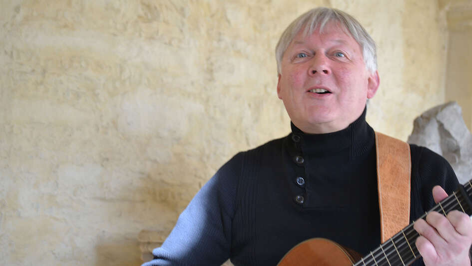 Der Liedermacher Fritz Baltruweit an der Gitarre Der Liedermacher Fritz Baltruweit an der Gitarre