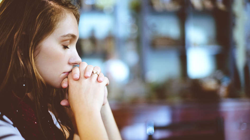 Junges Mädchen betet in der Kirche