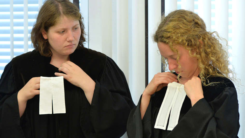 Studentinnen probieren Talar an Studentinnen probieren Talar an
