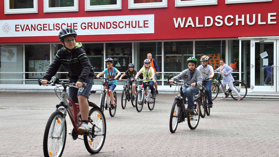 Kinder fahren auf dem Schulhof Fahrrad. Kinder fahren auf dem Schulhof Fahrrad.
