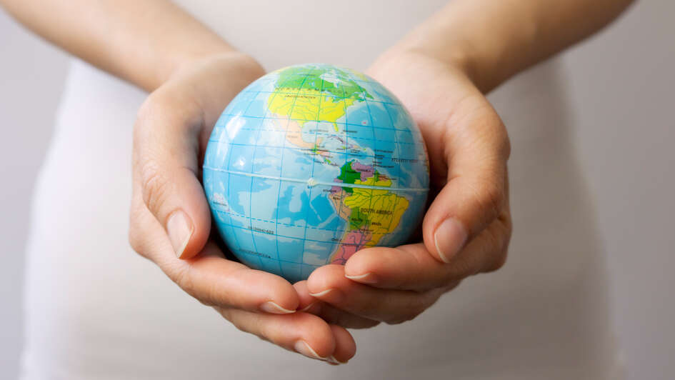Kleiner Globus liegt in Händen. Kleiner Globus liegt in Händen.