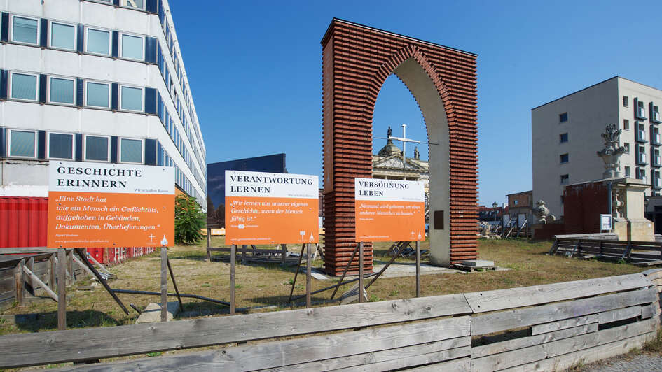 Der Bogen von der Grundsteinlegung zum Wiederaufbau der Potsdamer Garnisonskirche mit einer provisorischen Kapelle dahinter