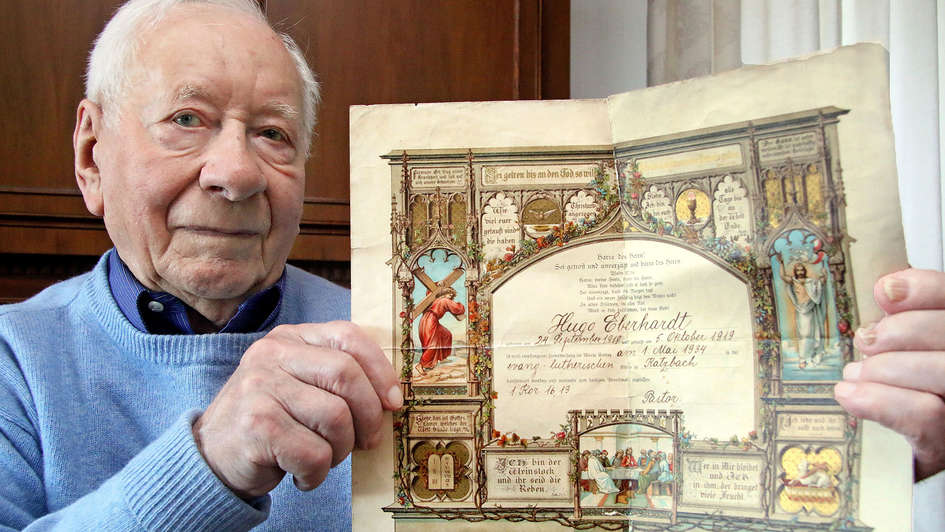 Der 98-jährige Hugo Eberhardt zeigt seine Konfirmationsurkunde