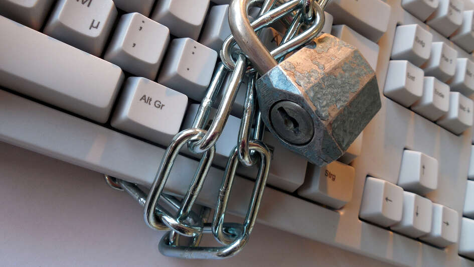 Mit einem Kettenschloss umwickelte Computer-Tastatur Mit einem Kettenschloss umwickelte Computer-Tastatur
