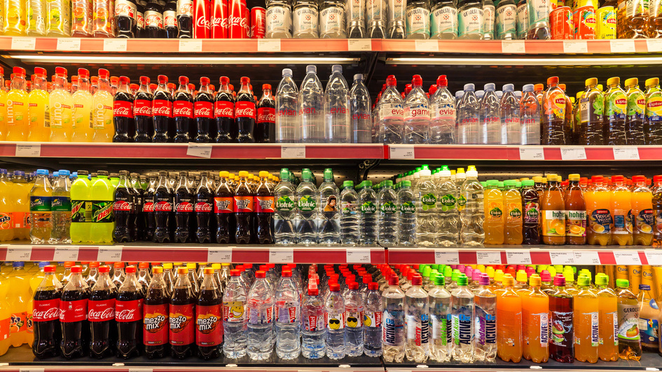 Regal im Supermarkt voller Getränke in Plastikflaschen