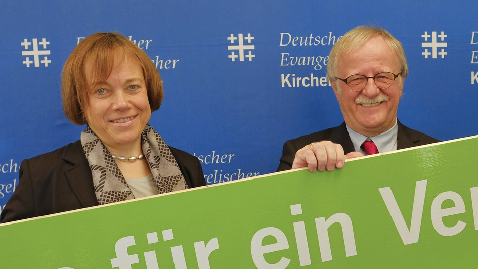 Kirchentagspräsident Hans Leyendecker und die stellvertretende EKD-Ratsvorsitzende Annette Kurschus halten ein Schild mit dem Kirchentagsmotto 2019