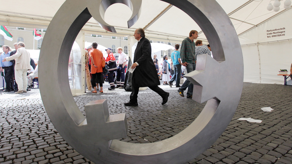 'Engel der Kulturen', eine metallene Intarsie, deren innere Form einen Engel symbolisiert, ist ein Kunstwerk von Gregor Merten und Carmen Dietrich, symbolisiert den Gedanken der Vermittlung zwischen den drei abrahamitischen Weltreligionen 'Engel der Kulturen', eine metallene Intarsie, deren innere Form einen Engel symbolisiert, ist ein Kunstwerk von Gregor Merten und Carmen Dietrich, symbolisiert den Gedanken der Vermittlung zwischen den drei abrahamitischen Weltreligionen