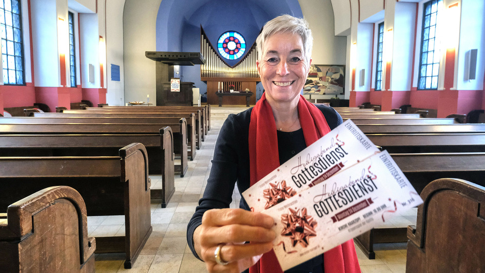 Presbyterin Christiane Imhof mit zeigt Eintrittskarten fuer den Heiligabend-Gottesdienst in der evangelischen Kirche in Essen-Haarzopf