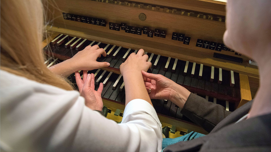 Eine 18-jährige Schülerin wird von einer Organistin an der Orgel unterrichtet