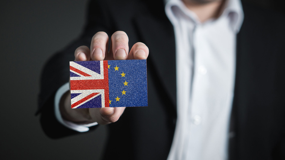 Mann hält eine Karte, die halb Großbritanniens, halb EU-Flagge darstellt Mann hält eine Karte, die halb Großbritanniens, halb EU-Flagge darstellt