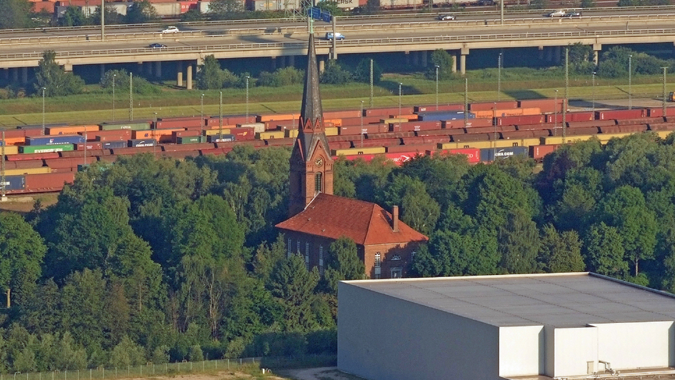 Kirche St. Gertrud in Hamburg-Altenwerder umgeben von Containern und Lagerhallen
