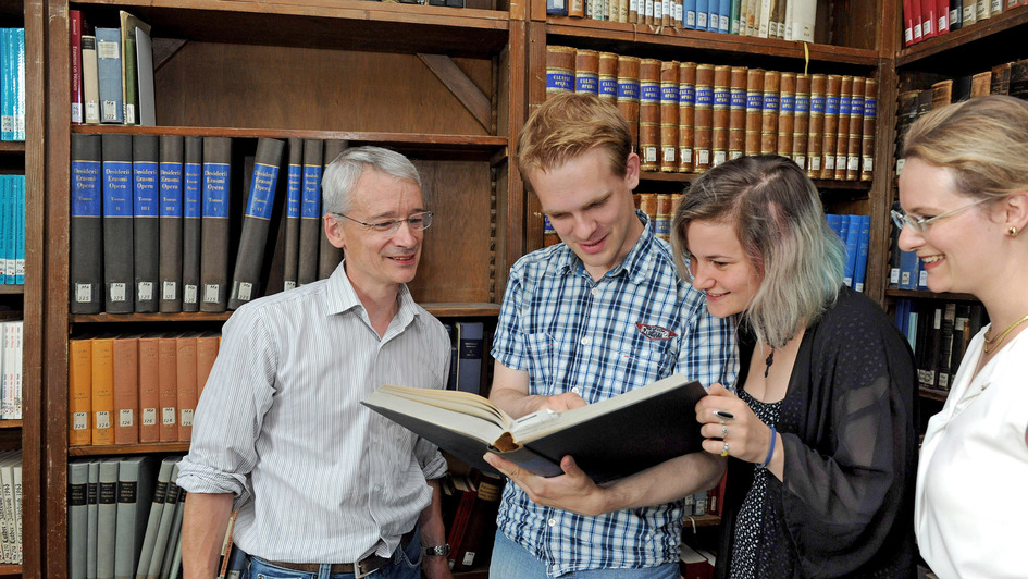 Theologiestudenten und -dozenten in einer Bibliothek